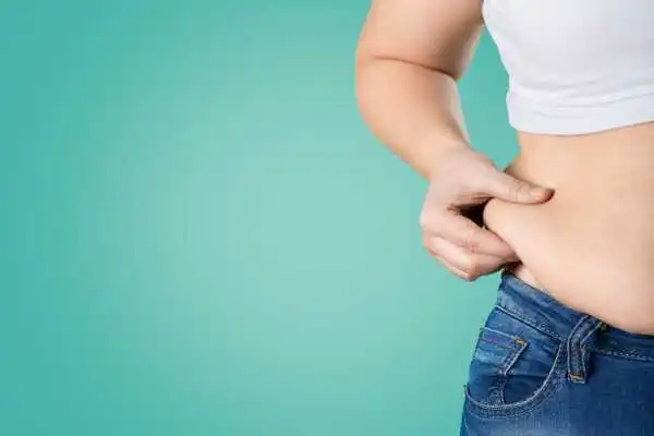 Image of woman pinching her love handles to show weight gain Hamilton